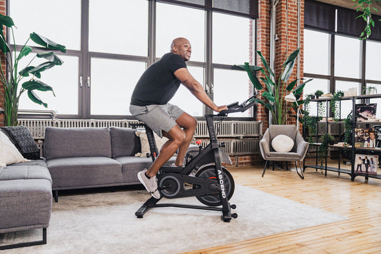 man pedaling on spin bike